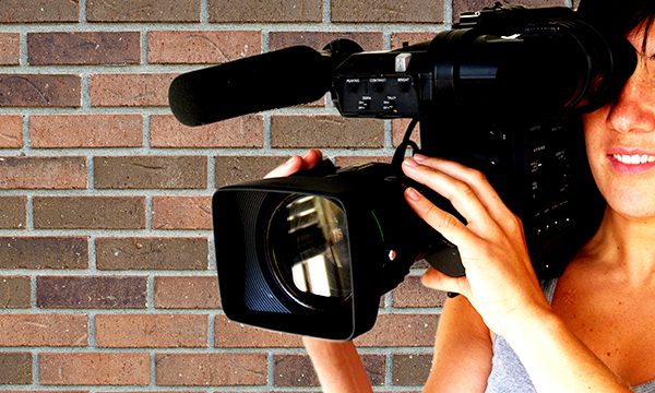 Kamerafrau filmt Teilnehmer an Medientraing